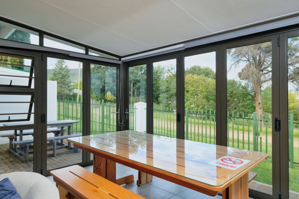 Moderne terrasoverkapping met glazen schuifwand en uitzicht op de tuin