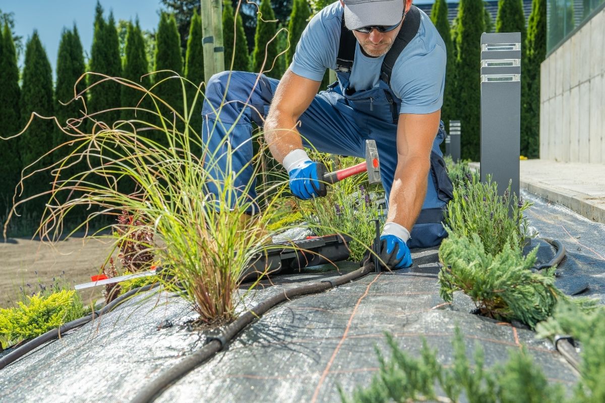 Druppelslang aanleggen onder worteldoek in een tuinborder